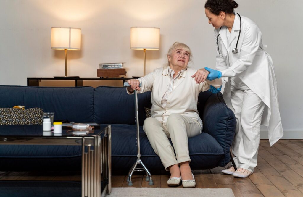 doctor-helping-her-old-patient-stand-up_23-2148962341