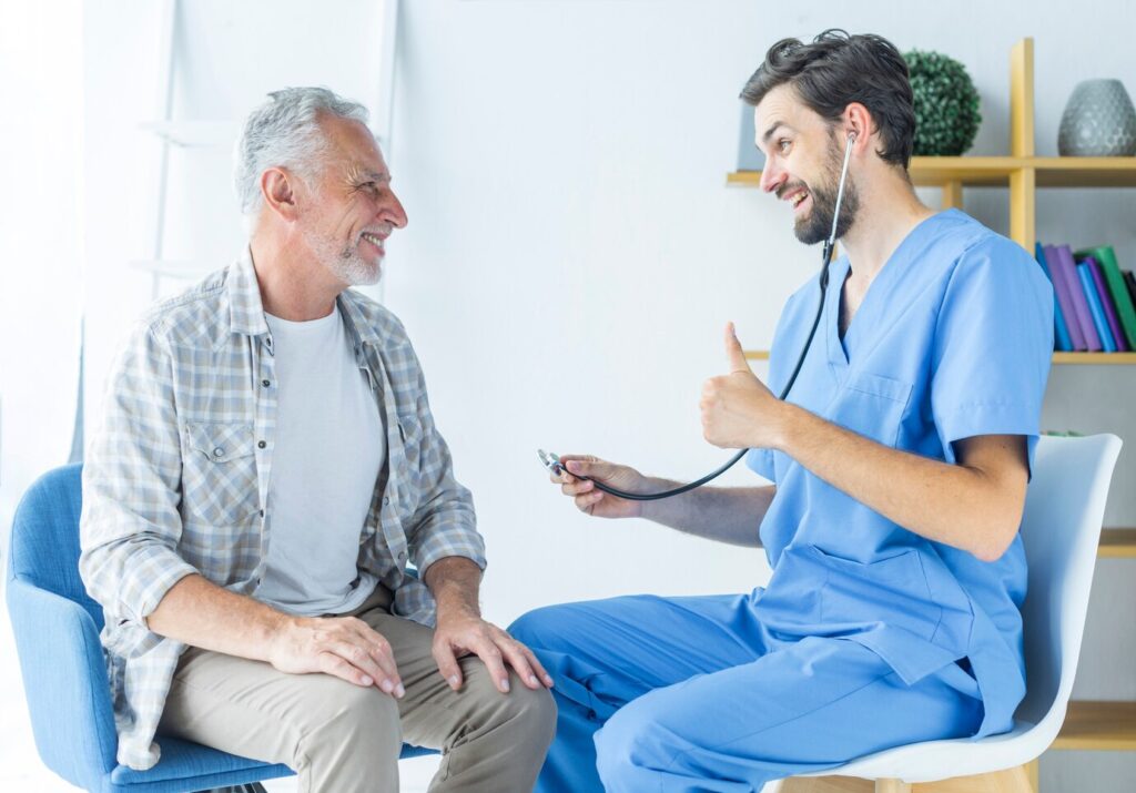 young-doctor-gesturing-thumb-up-elderly-patient_23-2147896891